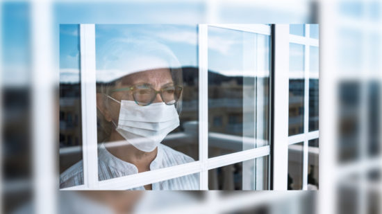 Lockdowns - Evidence Ineffective Coronavirus pandemic, senior woman in self quarantine to avoid contagion of infection by virus covid-19. Stays home looking outdoor from the window. Prevention concept