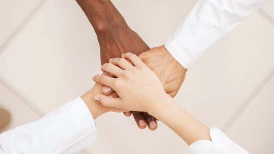 Doctors team. Top view of doctors team holding their hands together Doctors team. Top view of doctors team holding their hands together