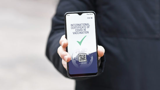 Concept for international Corona virus vaccine passport on mobile phone device to allow vaccinated people privileges